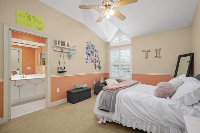 bedroom with ensuite bathroom, sink, vaulted ceiling, ceiling fan, and light colored carpet