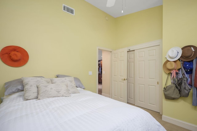 bedroom featuring a closet, visible vents, a towering ceiling, light carpet, and baseboards