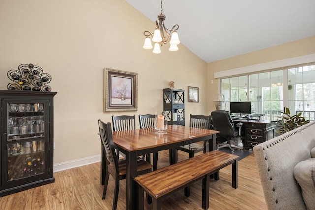 dining area with a chandelier, high vaulted ceiling, baseboards, and light wood-style floors