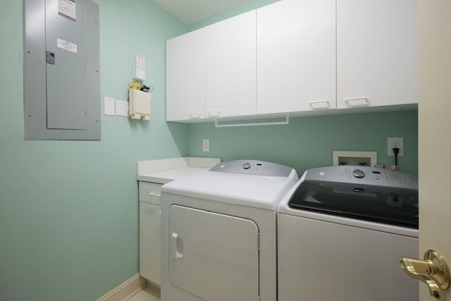 laundry room with cabinets, washing machine and dryer, and electric panel