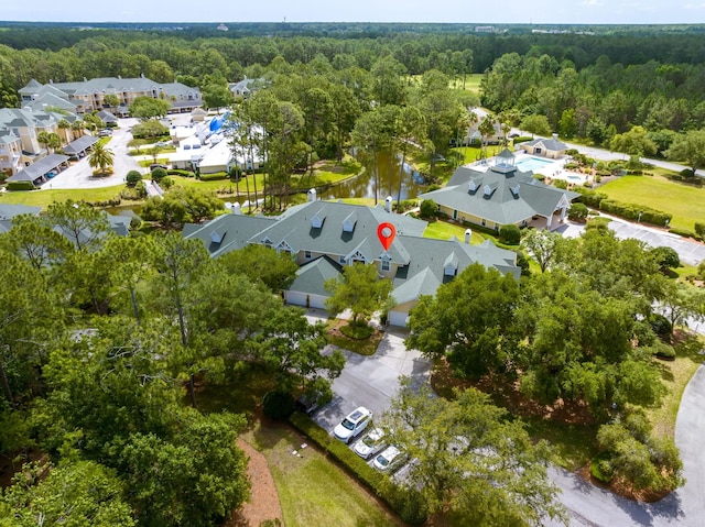 drone / aerial view with a residential view, a water view, and a forest view