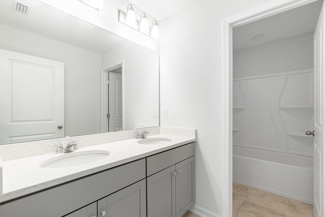 full bathroom featuring double vanity, a sink, visible vents, and tile patterned floors