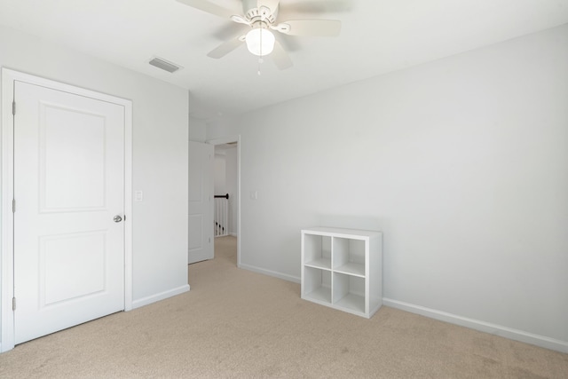 unfurnished bedroom featuring ceiling fan and light carpet