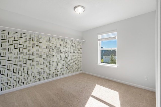 carpeted empty room featuring baseboards