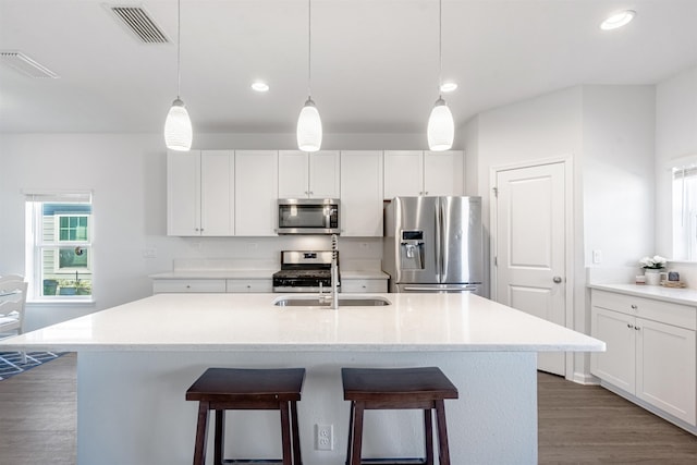 kitchen featuring stainless steel appliances, a breakfast bar, and visible vents