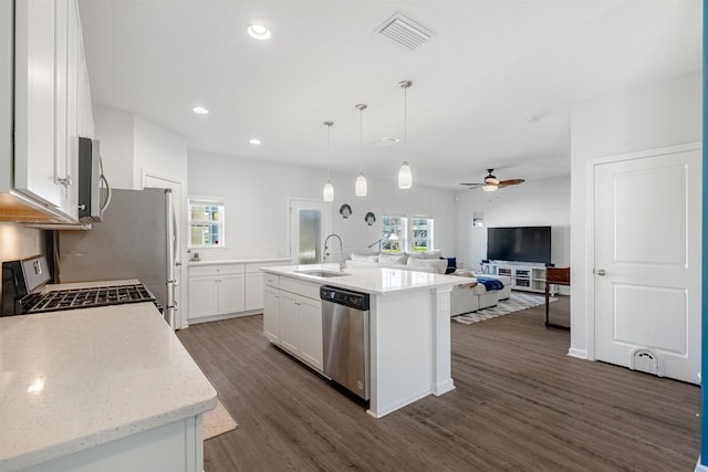 kitchen with dark wood finished floors, visible vents, appliances with stainless steel finishes, open floor plan, and a sink