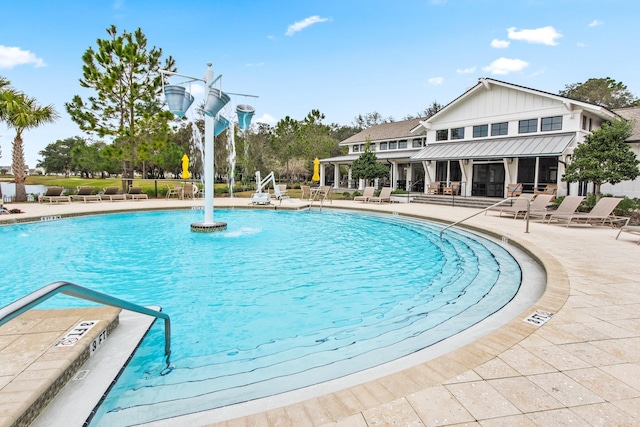 view of swimming pool featuring pool water feature and a patio