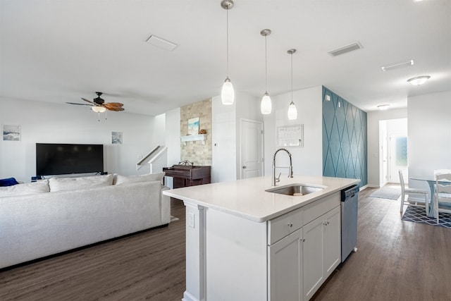 kitchen with pendant lighting, dishwasher, sink, an island with sink, and white cabinetry