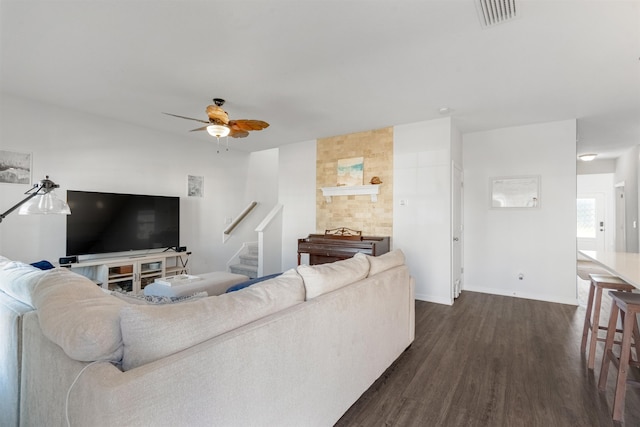 living room featuring ceiling fan and dark wood-type flooring