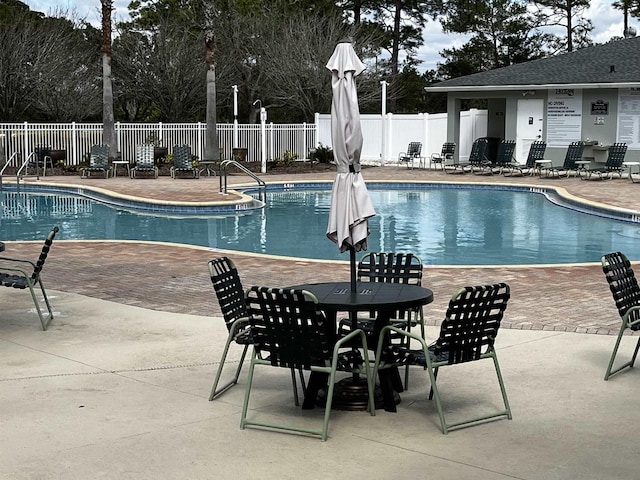 pool with a patio and fence