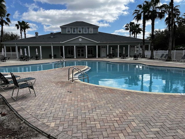 pool with a patio and fence