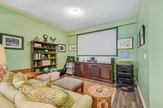 cinema room with a textured ceiling and wood finished floors