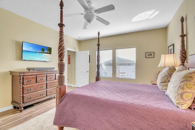 bedroom featuring a textured ceiling, ceiling fan, light wood-style flooring, and baseboards