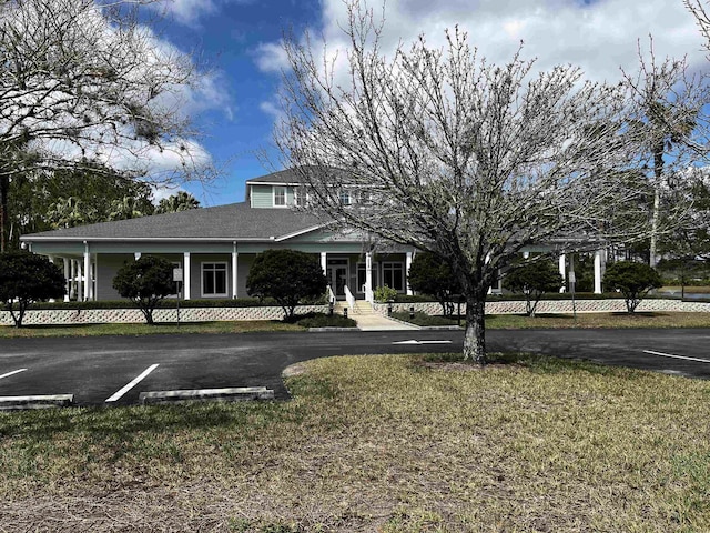 view of front of property with uncovered parking and a front lawn