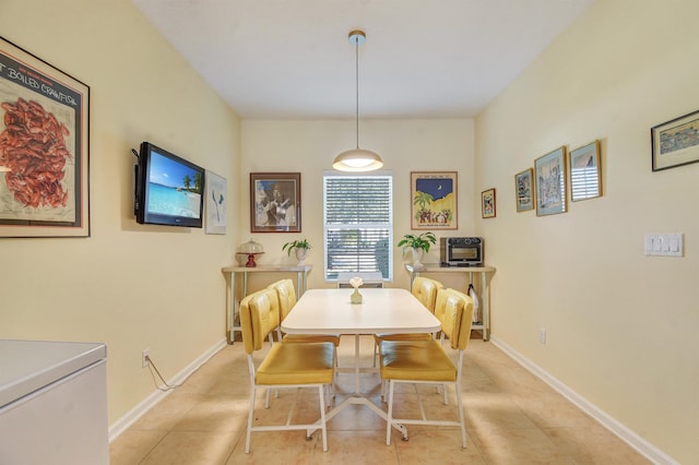 dining room featuring light tile patterned floors and baseboards