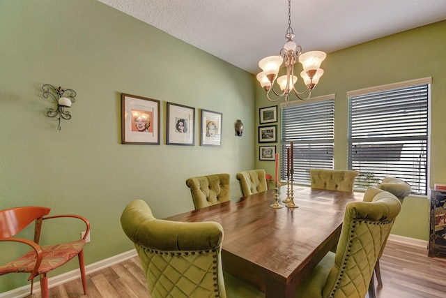 dining space with light wood-style floors, baseboards, and a chandelier