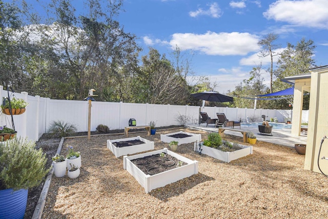 view of yard with a fenced in pool, a garden, and a fenced backyard