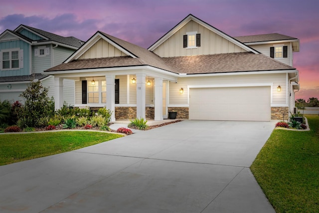 craftsman house with a garage, covered porch, and a lawn