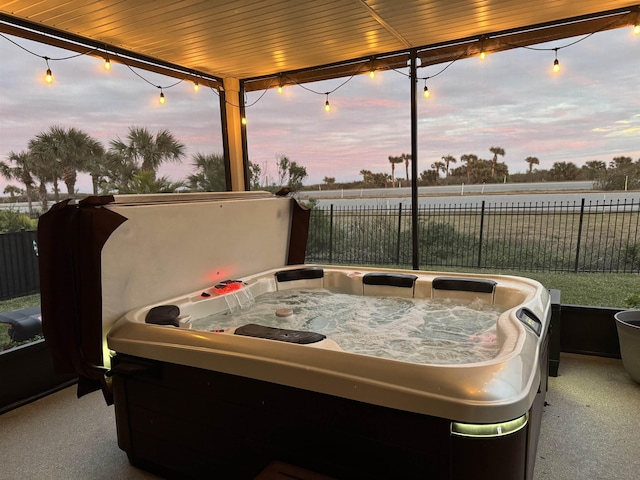 patio terrace at dusk featuring a hot tub