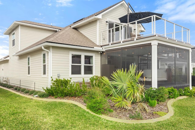 view of property exterior featuring a balcony, a yard, and a sunroom