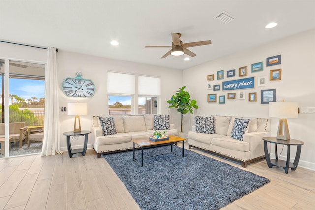 living room with ceiling fan, hardwood / wood-style floors, and a wealth of natural light