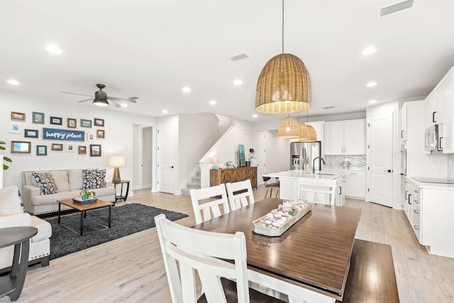 dining space featuring sink, light hardwood / wood-style flooring, and ceiling fan