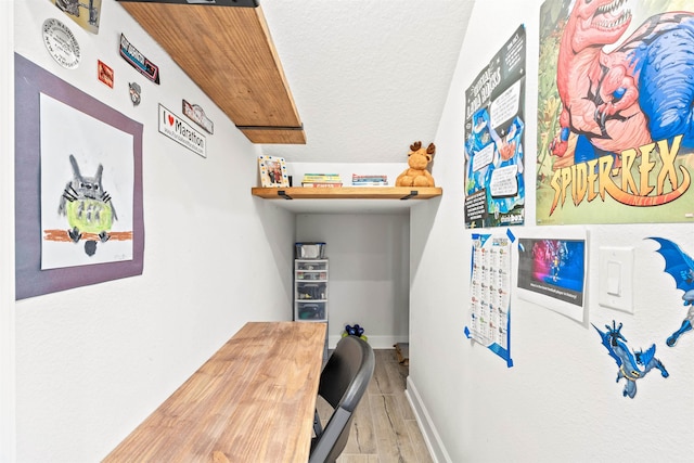 home office with hardwood / wood-style floors and a textured ceiling