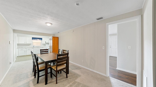 dining space featuring a textured ceiling and light wood-type flooring