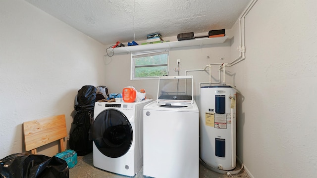 clothes washing area featuring water heater, washer and clothes dryer, and a textured ceiling