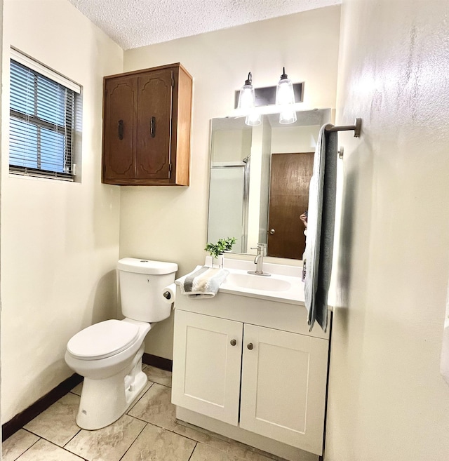 bathroom featuring toilet, vanity, tile patterned flooring, and a textured ceiling