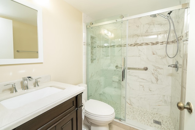 bathroom featuring vanity, toilet, and a shower stall