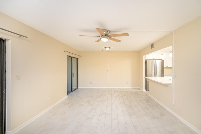 spare room with visible vents, baseboards, ceiling fan, and light wood finished floors