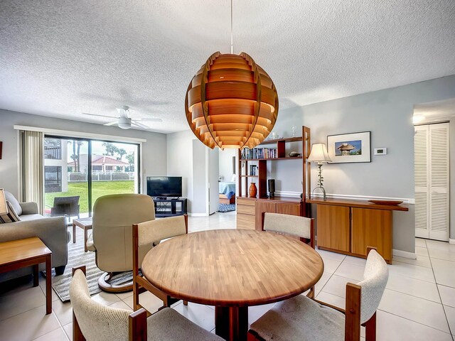 dining area featuring light tile patterned floors, a textured ceiling, and ceiling fan