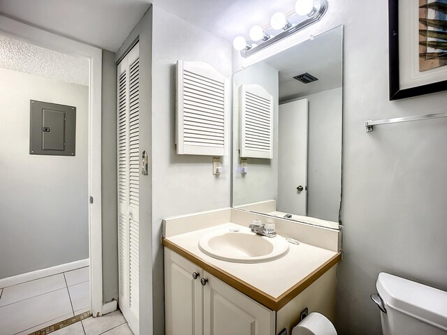 bathroom featuring tile patterned floors, vanity, radiator heating unit, electric panel, and toilet