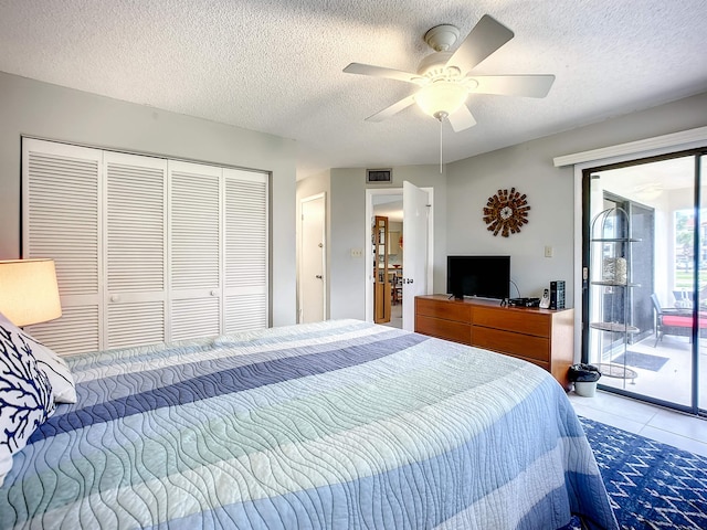 bedroom featuring access to exterior, tile patterned floors, a textured ceiling, ceiling fan, and a closet