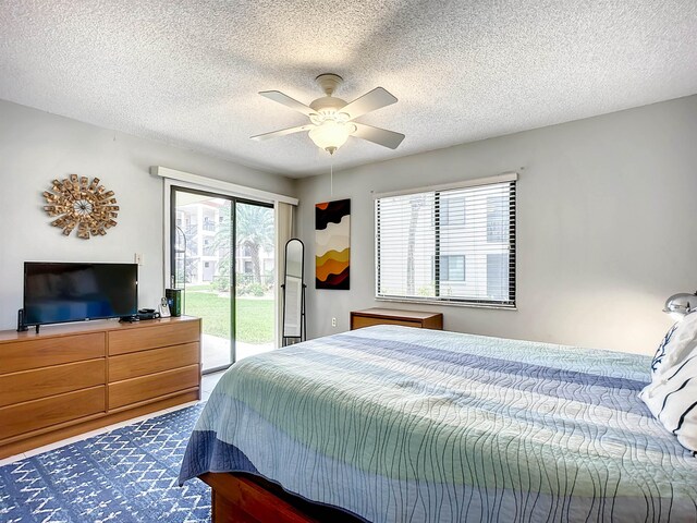 bedroom featuring hardwood / wood-style floors, ceiling fan, a textured ceiling, and access to outside