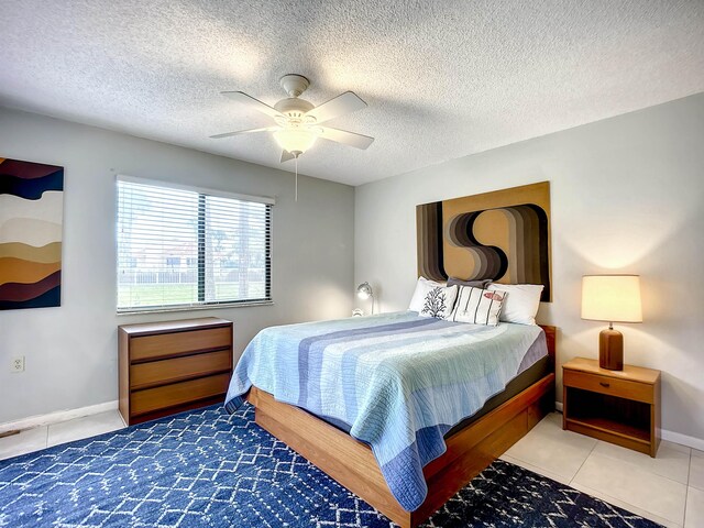 tiled bedroom with a textured ceiling and ceiling fan