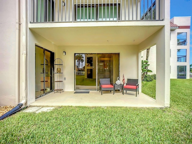 exterior space with a balcony, a patio area, and a lawn