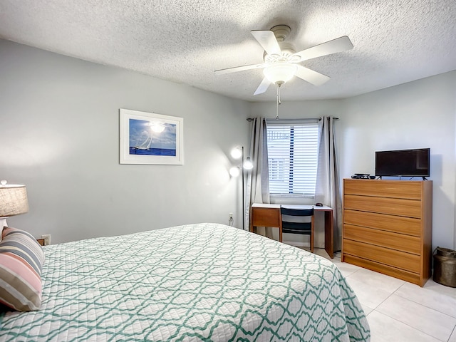 tiled bedroom featuring ceiling fan and a textured ceiling