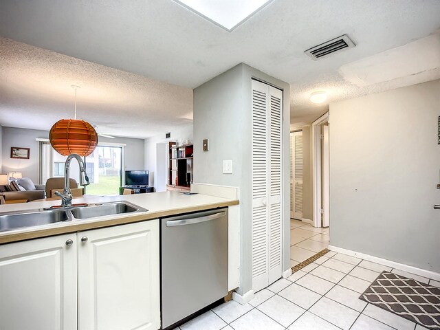 kitchen with dishwasher, sink, white cabinets, a textured ceiling, and light tile patterned floors