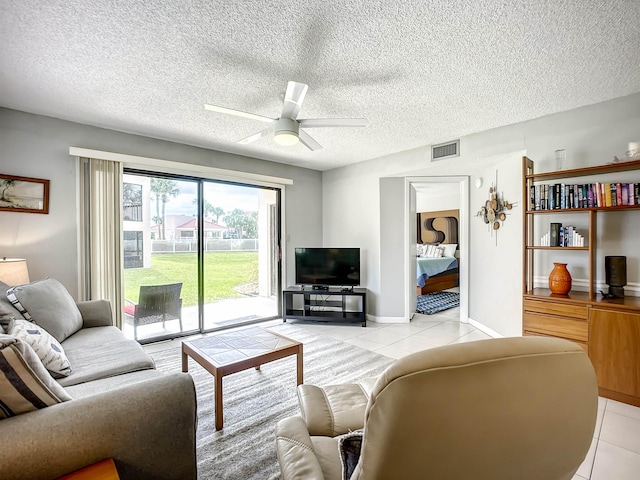 tiled living room with ceiling fan and a textured ceiling