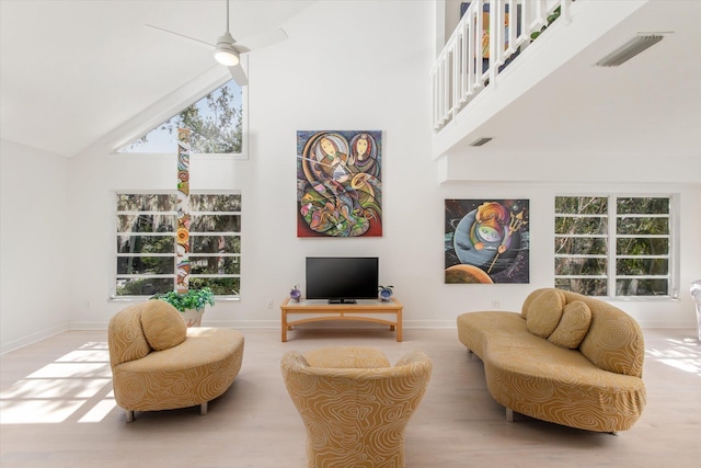 living area featuring ceiling fan, a wealth of natural light, and high vaulted ceiling