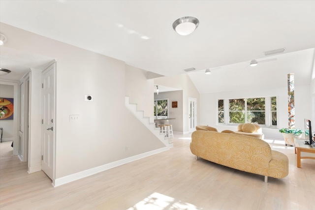 living room featuring plenty of natural light, lofted ceiling, and light hardwood / wood-style floors