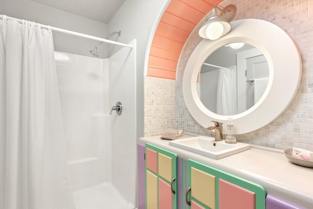 bathroom featuring vanity, curtained shower, and decorative backsplash