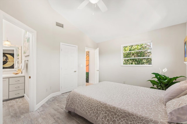 bedroom featuring ensuite bathroom, lofted ceiling, ceiling fan, and light hardwood / wood-style flooring