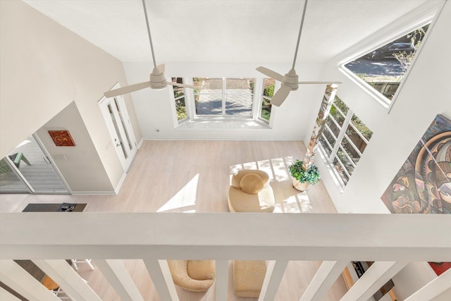 stairway featuring high vaulted ceiling, hardwood / wood-style floors, and ceiling fan