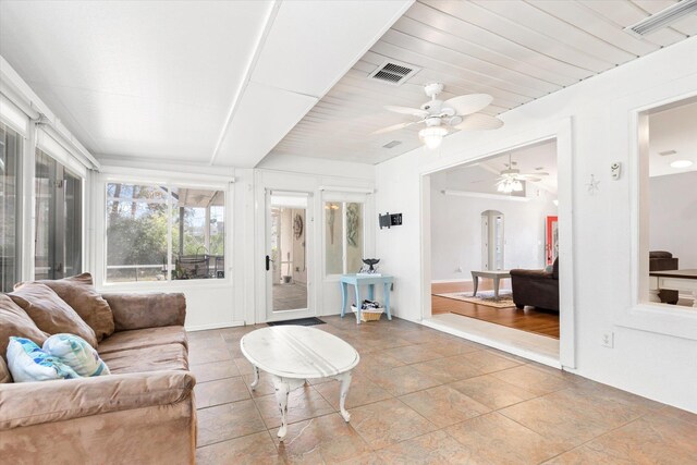 bedroom with ensuite bathroom, ceiling fan, a tray ceiling, crown molding, and dark wood-type flooring