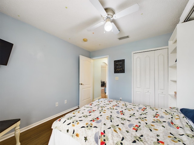 bedroom featuring dark hardwood / wood-style floors, ceiling fan, and a closet