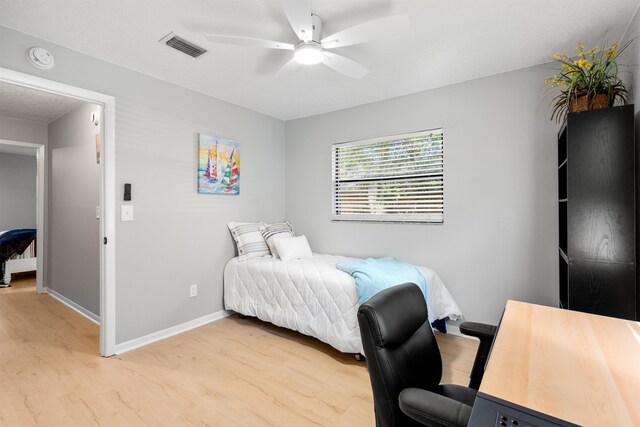 bedroom featuring light wood-type flooring, baseboards, visible vents, and a ceiling fan