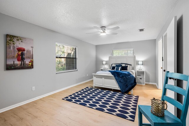 bedroom with light wood finished floors, baseboards, and visible vents